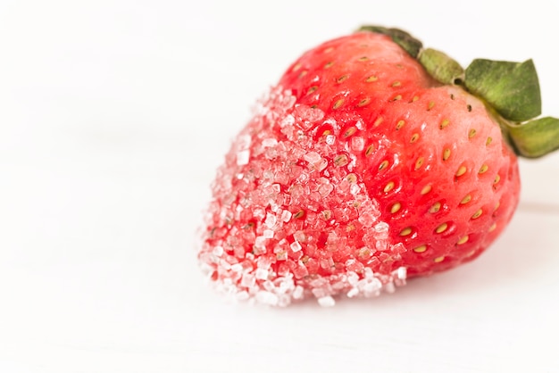 Fresa roja fresca con azúcar sobre fondo blanco