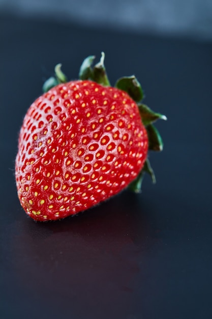 Foto gratuita fresa roja fresca sobre superficie oscura. de cerca