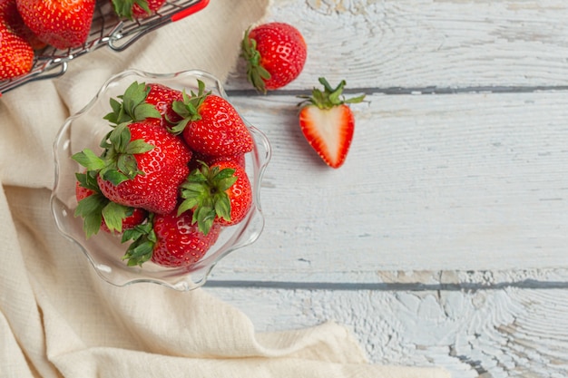 Fresas frescas en vidrio sobre mesa de madera