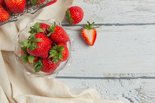 Fresas frescas en vidrio sobre mesa de madera