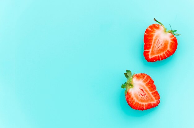 Fresas maduras a la mitad jugosas con tallos verdes