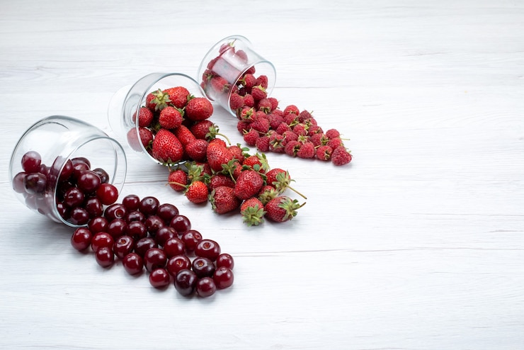Foto gratuito fresas rojas frescas con cerezas agrias frescas y frambuesas a la luz