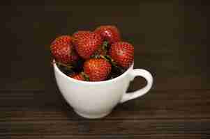 Foto gratuita fresas rojas en una taza blanca