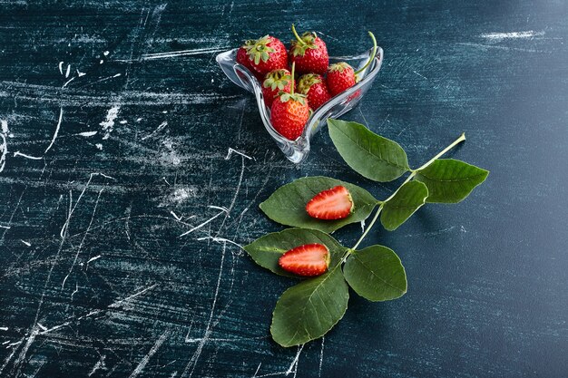 Fresas en una taza de cristal decorativa.