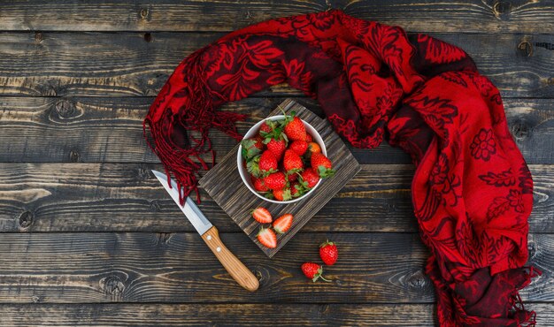 Fresas en un tazón con cuchillo y pañuelo rojo