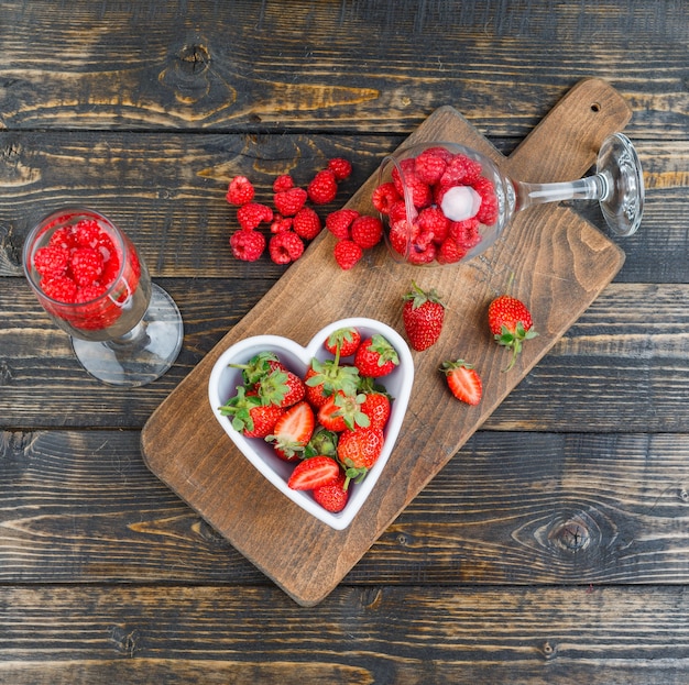 Fresas en un tazón con frambuesas en vasos