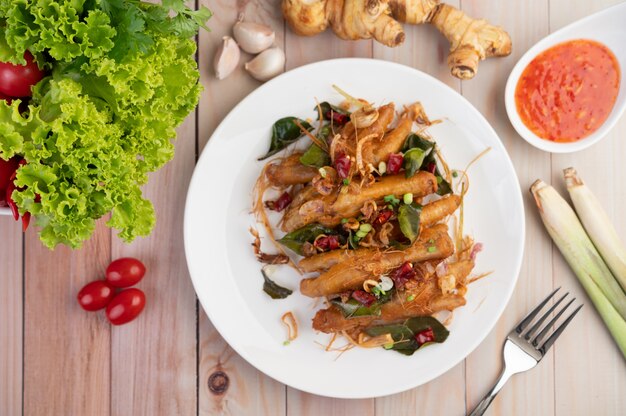 Fried Chicken Feet con hierbas en un plato blanco y salsa de inmersión.