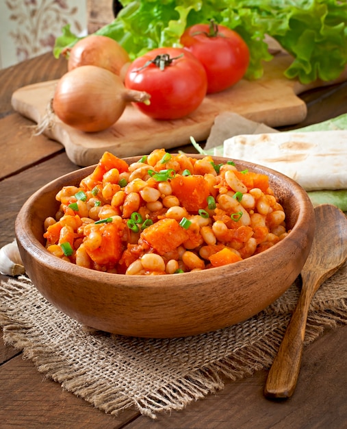 Frijoles blancos guisados y rodajas de calabaza en salsa de tomate