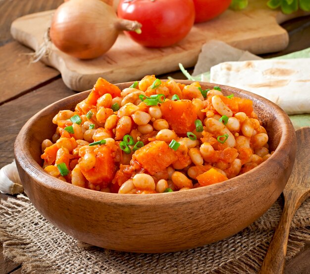 Frijoles blancos guisados y rodajas de calabaza en salsa de tomate