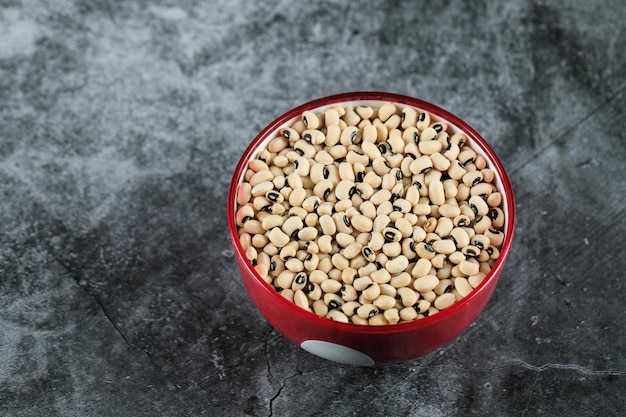 Frijoles blancos secos en un tazón rojo