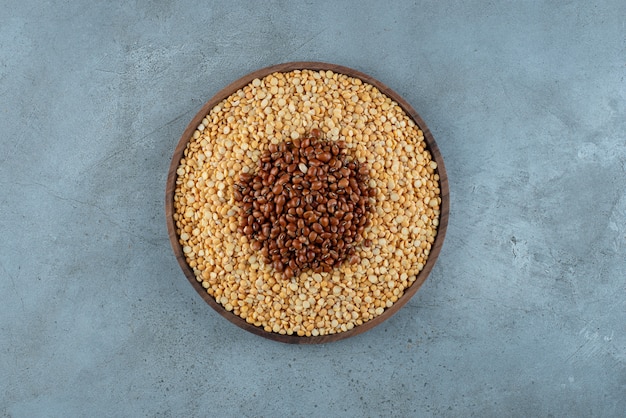 Frijoles y guisantes en un plato de madera. Foto de alta calidad