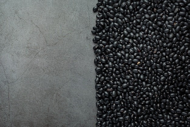 Foto gratuita frijoles negros y fondo de cemento desnudo