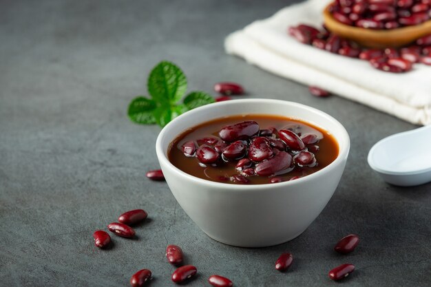 Frijoles rojos hervidos en un tazón blanco sobre un piso oscuro