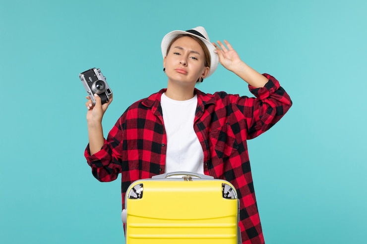 Photo Gratis front view young female going in voyage and holding camera on blue space