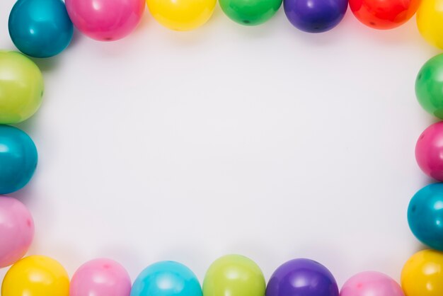 Frontera de globos de colores sobre fondo blanco con espacio para escribir texto