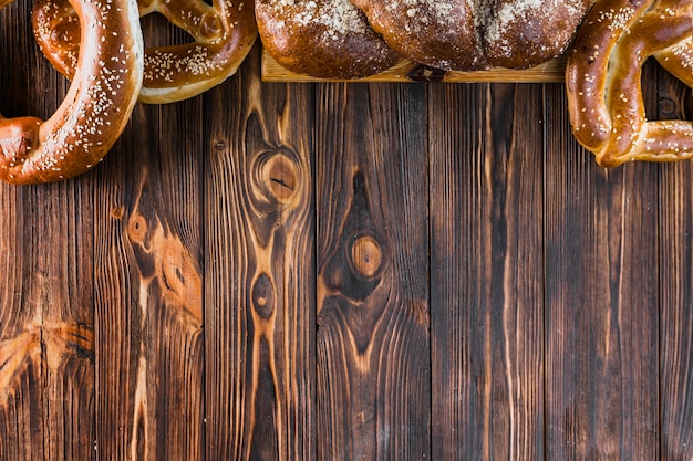Frontera hecha con pan trenzado y pretzels en el fondo de madera