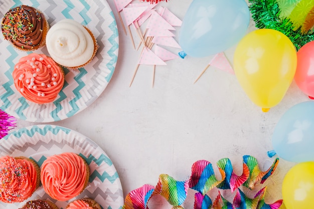 Foto gratuita frontera de muffins y decoraciones de cumpleaños