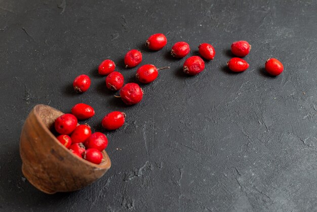 Fruta de cereza roja fresca en un recipiente marrón sobre fondo gris