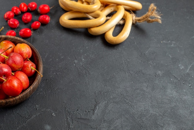 Fruta de cereza roja fresca en un recipiente sobre fondo gris