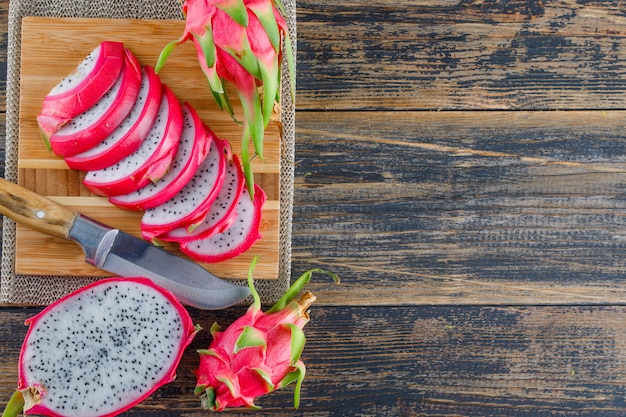 Fruta del dragón con tabla de cortar, cuchillo plano en mesa de madera