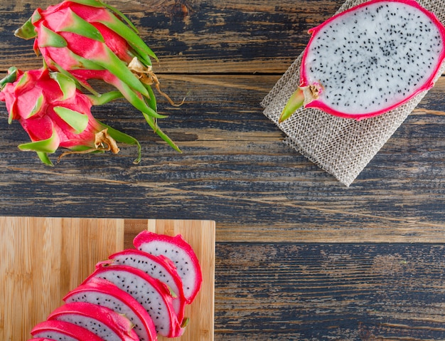 Fruta del dragón con tabla de cortar plana yacía sobre la mesa de madera