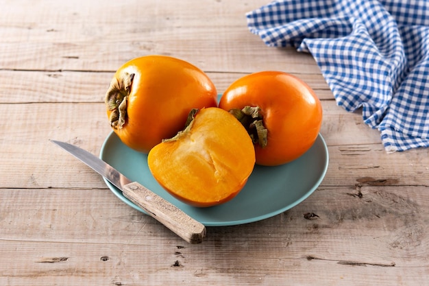 Fruta fresca de caqui en mesa de madera