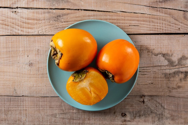 Fruta fresca de caqui en mesa de madera