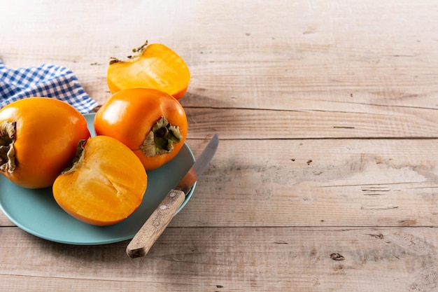 Fruta fresca de caqui en mesa de madera