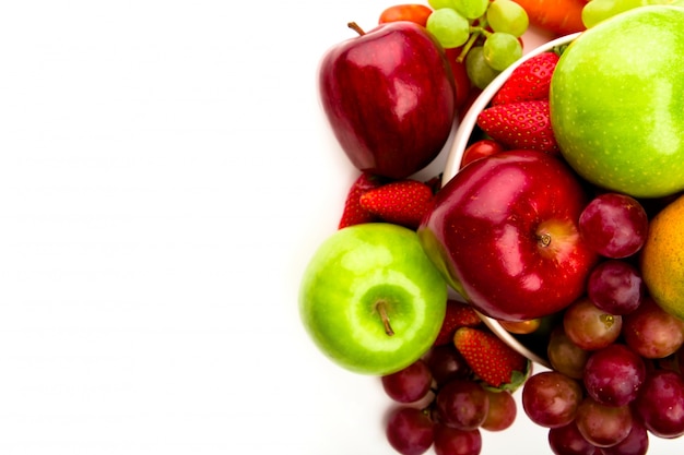 La fruta fresca en un plato aislado en blanco