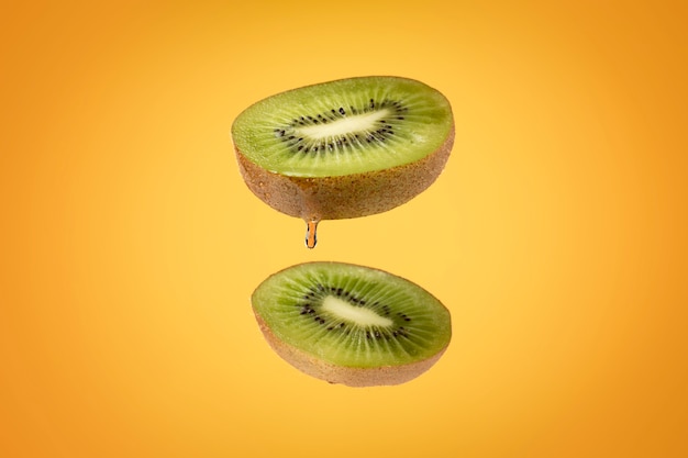 Foto gratuita fruta de kiwi en rodajas flotantes con fondo claro