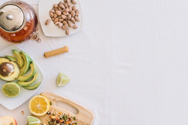 Foto gratuita fruta saludable con frutos secos y tetera sobre fondo blanco