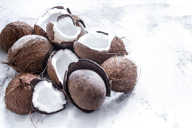 Foto gratuita fruta tropical de coco rozbitogo reducido a la mitad sobre un fondo claro, el concepto de fruta orgánica