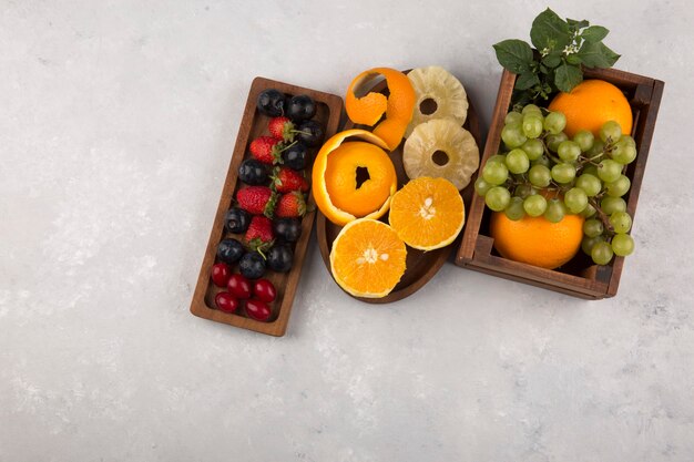 Frutas y bayas mixtas en platos de madera en el centro