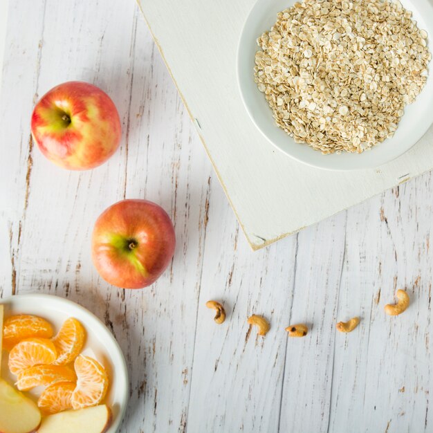 Foto gratuita frutas cerca del tazón con harina de avena