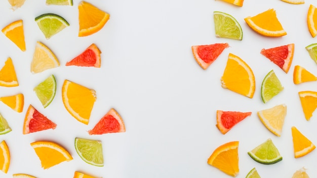 Frutas cítricas coloridas dispuestas con espacio para escribir texto sobre fondo blanco