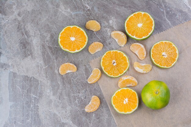 Frutas cítricas esparcidas sobre fondo de piedra.