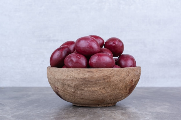 Frutas encurtidas caseras en tazón de madera.