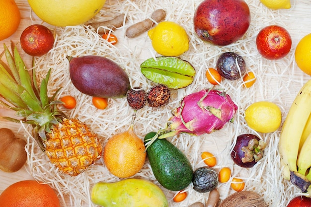 Frutas exóticas sobre fondo de madera Alimentación saludable dieta comida Pitahaya carambola papaya bebé piña mango maracuyá tamarindo y otros
