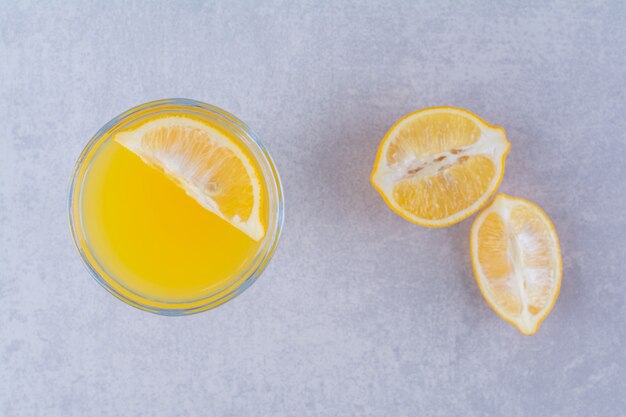 Frutas frescas de naranja y jugo de mesa de mármol.