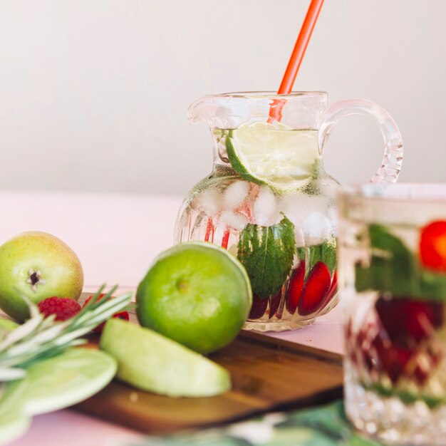 Frutas frescas en la tabla de cortar en frente del jugo en el vaso