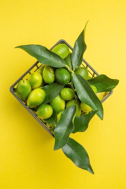 frutas con hojas frutas verdes con hojas en la canasta gris sobre la mesa