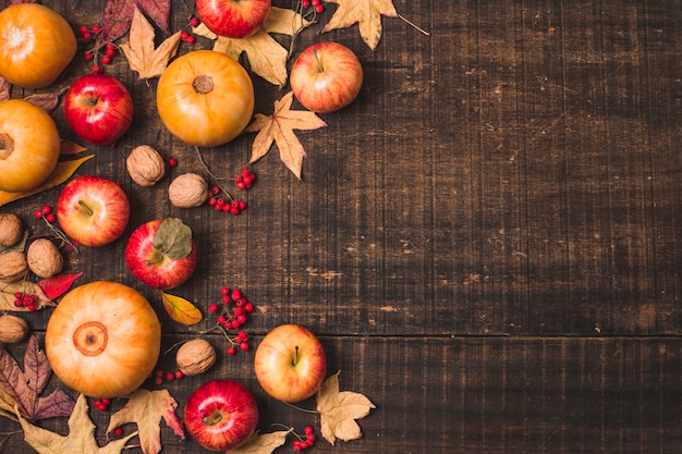 Frutas y hojas de otoño sobre fondo de madera