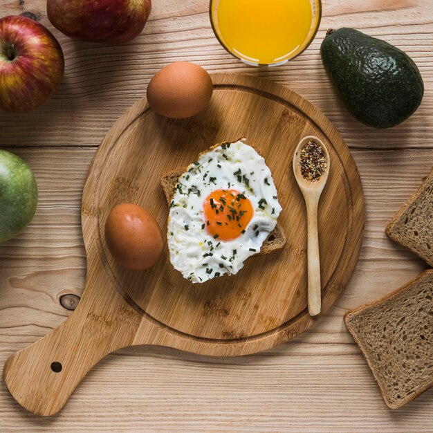 Frutas y jugo cerca de pan tostado con huevo frito