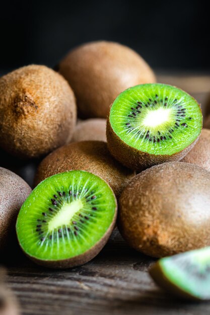 Frutas maduras de kiwi cortadas y enteras de cerca