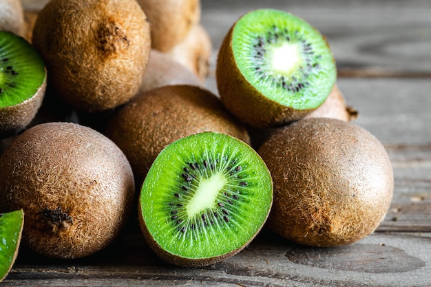 Frutas maduras de kiwi cortadas y enteras de cerca