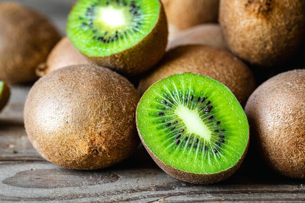 Frutas maduras de kiwi cortadas y enteras de cerca