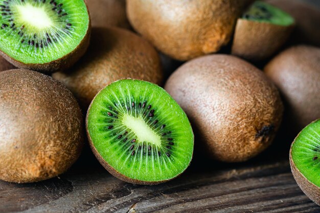 Frutas maduras de kiwi cortadas y enteras de cerca