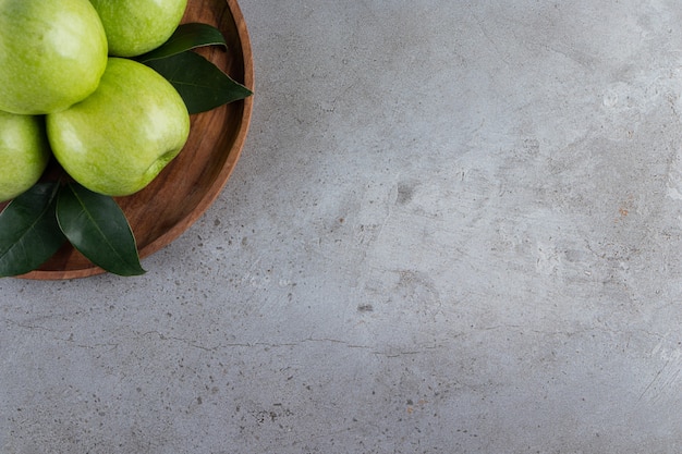 Frutas de manzana verde enteras colocadas sobre la mesa de piedra