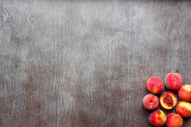 Frutas de melocotones frescos sobre fondo rústico de madera oscura, vista superior. Copie el espacio. Naturaleza muerta. Endecha plana.