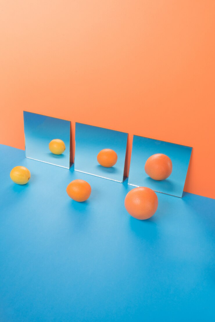 Foto gratuito frutas en mesa azul aislado en naranja cerca de espejos
